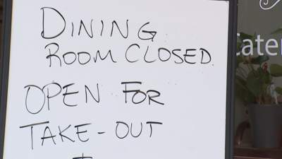 Whiteboard sign: Dining room closed. Open for take-out.